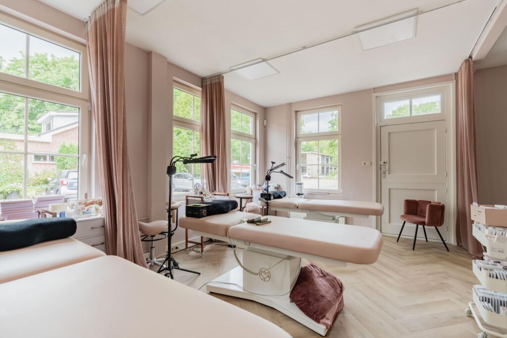 Bright and modern beauty treatment room with multiple beds, equipment, and large windows at Sloterweg.