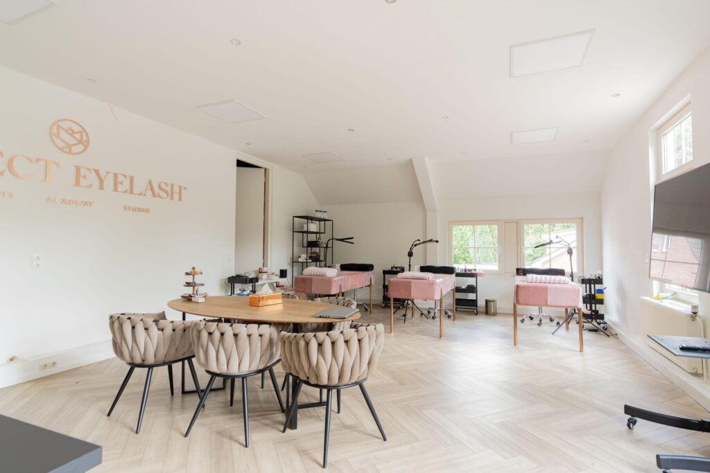 Bright and modern beauty studio with pink treatment beds and a stylish seating area at Perfect Eyelash on Sloterweg.