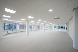 Leeg, wit afgewerkt kantoorpand aan de Kuiperbergweg met systeemplafond en grote raampartijen.
