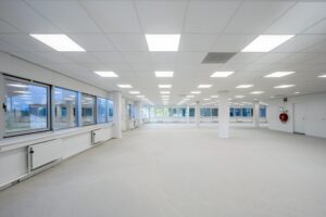 Lichte, leegstaande kantoorruimte aan de Kuiperbergweg met systeemplafond en grote ramen.