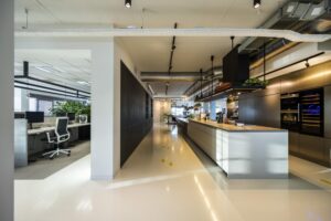 Moderne kantoorruimte aan de Kuiperbergweg met open werkplekken en een strakke keuken met bar.