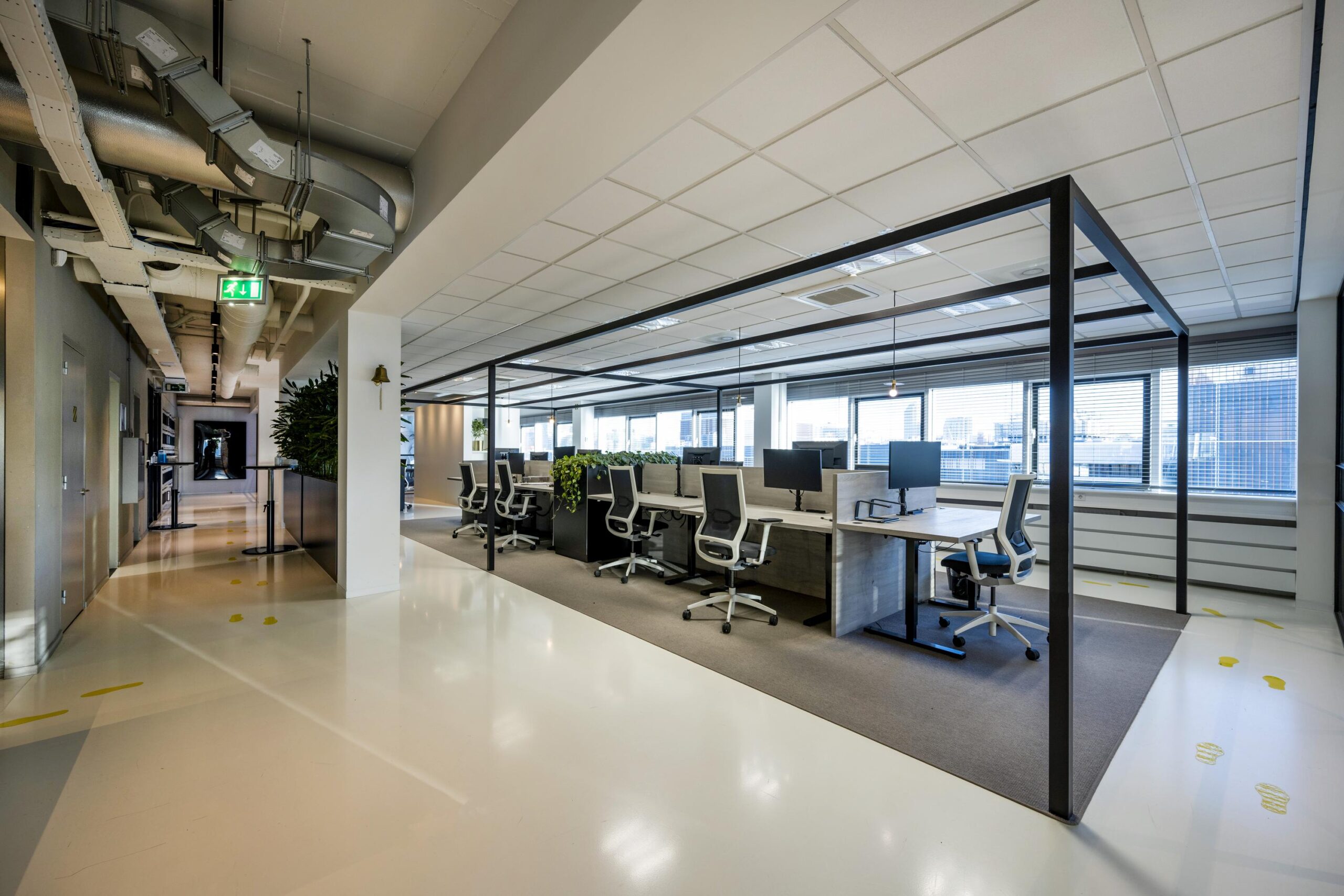 Modern open-plan office interior at Kuiperbergweg with workstations, ergonomic chairs, and large windows.