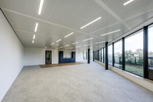 Modern, unfurnished office space on Gelrestraat with large windows, built-in kitchenette, and ample natural light.