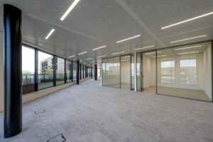 Modern empty office space on Gelrestraat with large windows and glass-walled meeting rooms.