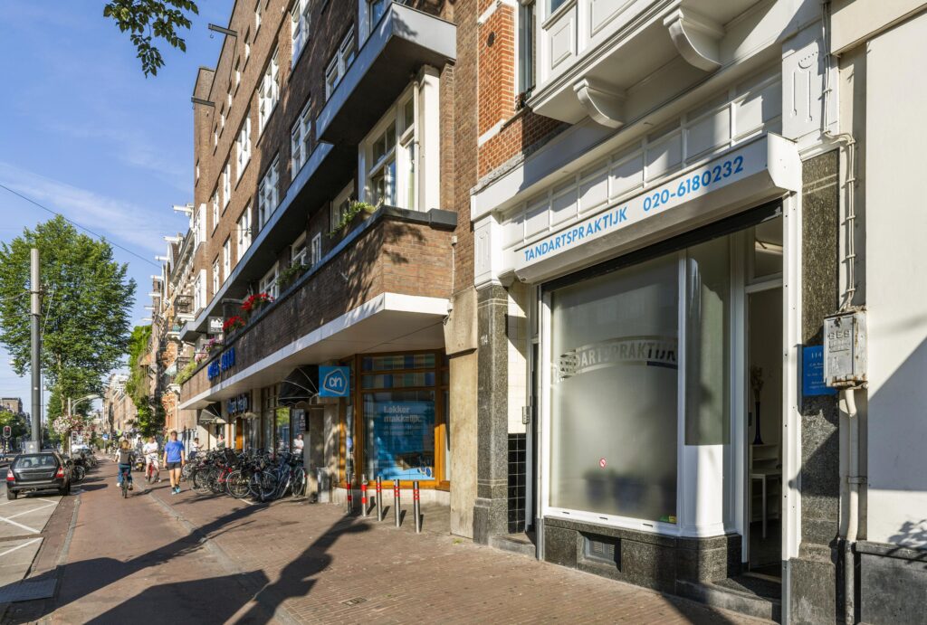 Street view of Overtoom in Amsterdam featuring a dental practice and an Albert Heijn supermarket.