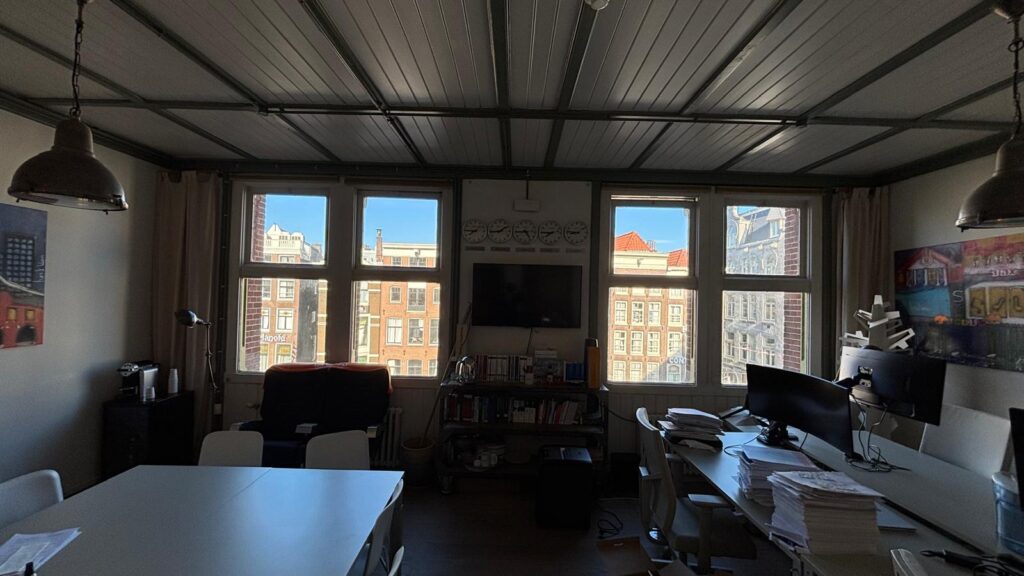 Modern office space with large windows overlooking Damrak in Amsterdam.
