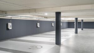 Underground parking area with multiple electric vehicle charging stations and designated charging bays.