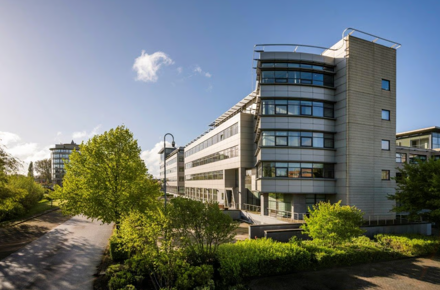Modern kantoorgebouw aan de Boeing Avenue omringd door groene beplanting en een helderblauwe lucht.
