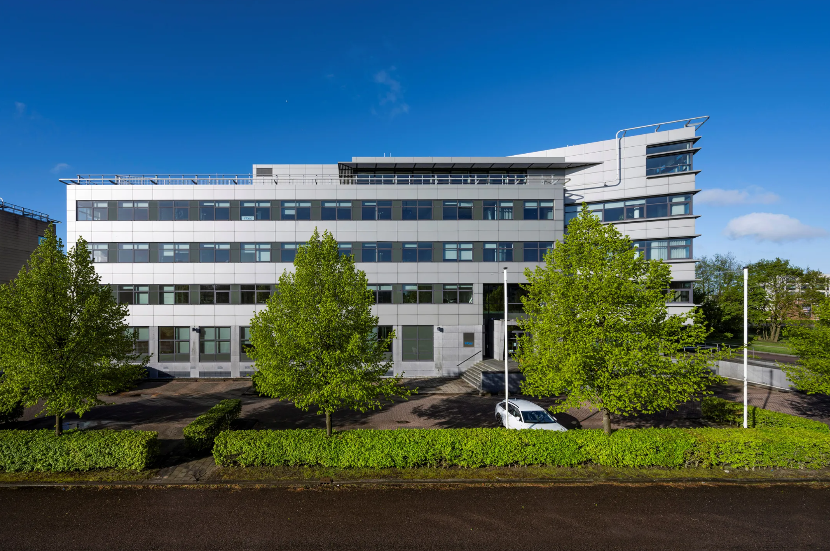 Modern office building on Boeing Avenue with large windows and trees in front.