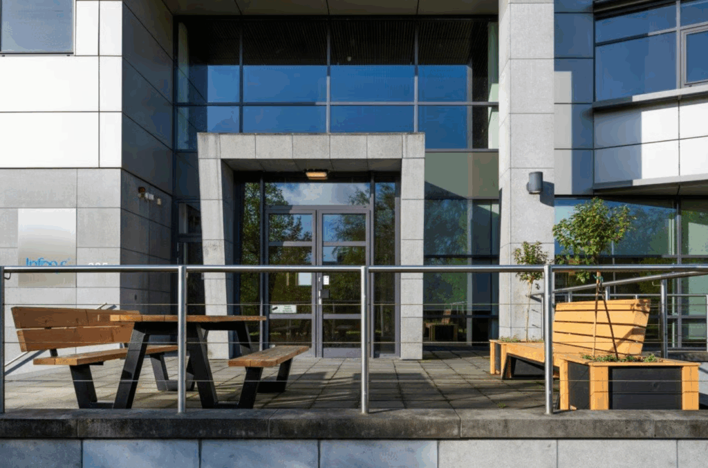 Modern office building entrance at Boeing Avenue with outdoor seating and planter benches.