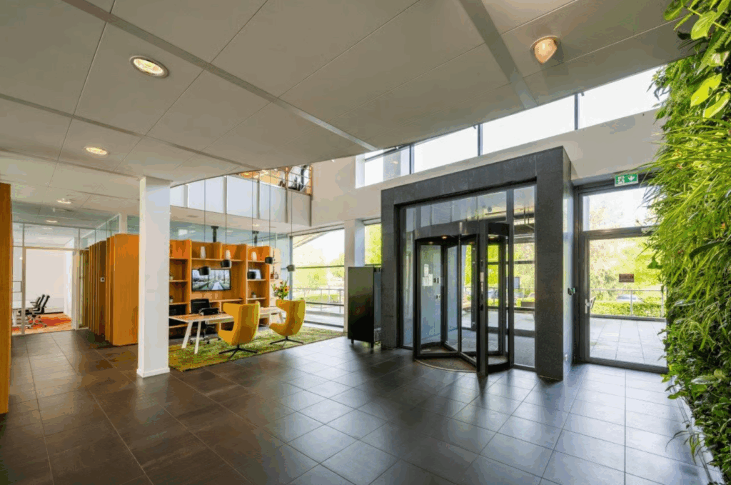 Modern office entrance at Boeing Avenue with a revolving door, green wall, and seating area.
