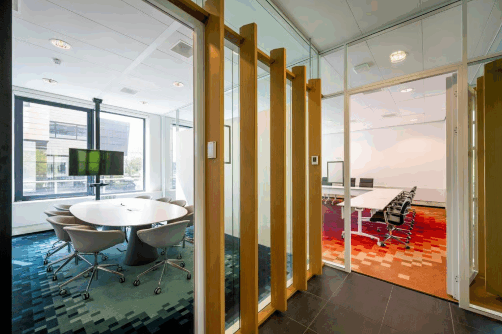 Modern office meeting rooms with glass walls, colorful carpets, and contemporary furniture on Boeing Avenue.