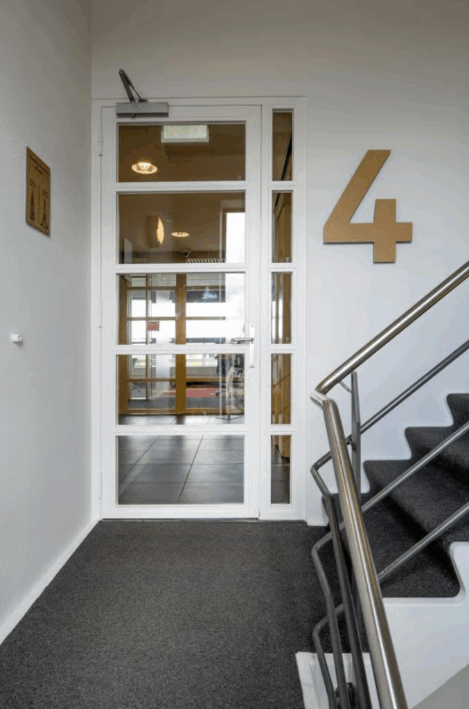 Stairwell on the fourth floor with a glass door leading to an office hallway in Boeing Avenue.