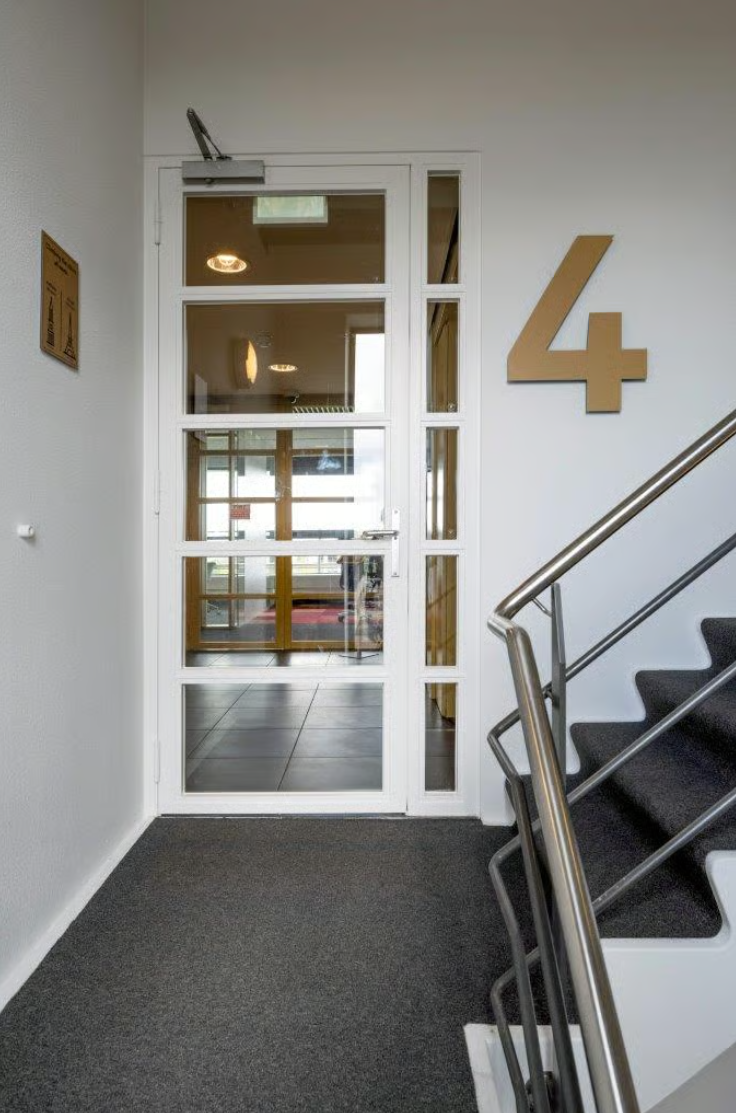 Stairwell on the fourth floor with a glass door leading to an office hallway in Boeing Avenue.