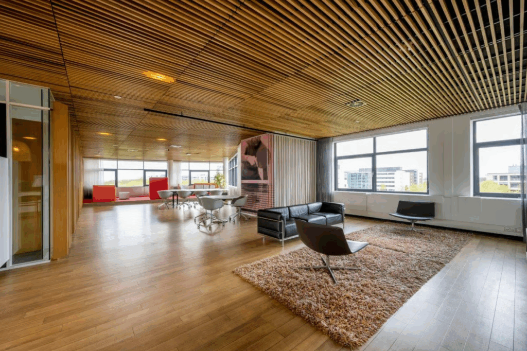Modern open office space on Boeing Avenue with wooden flooring, lounge area, and large windows offering natural light.