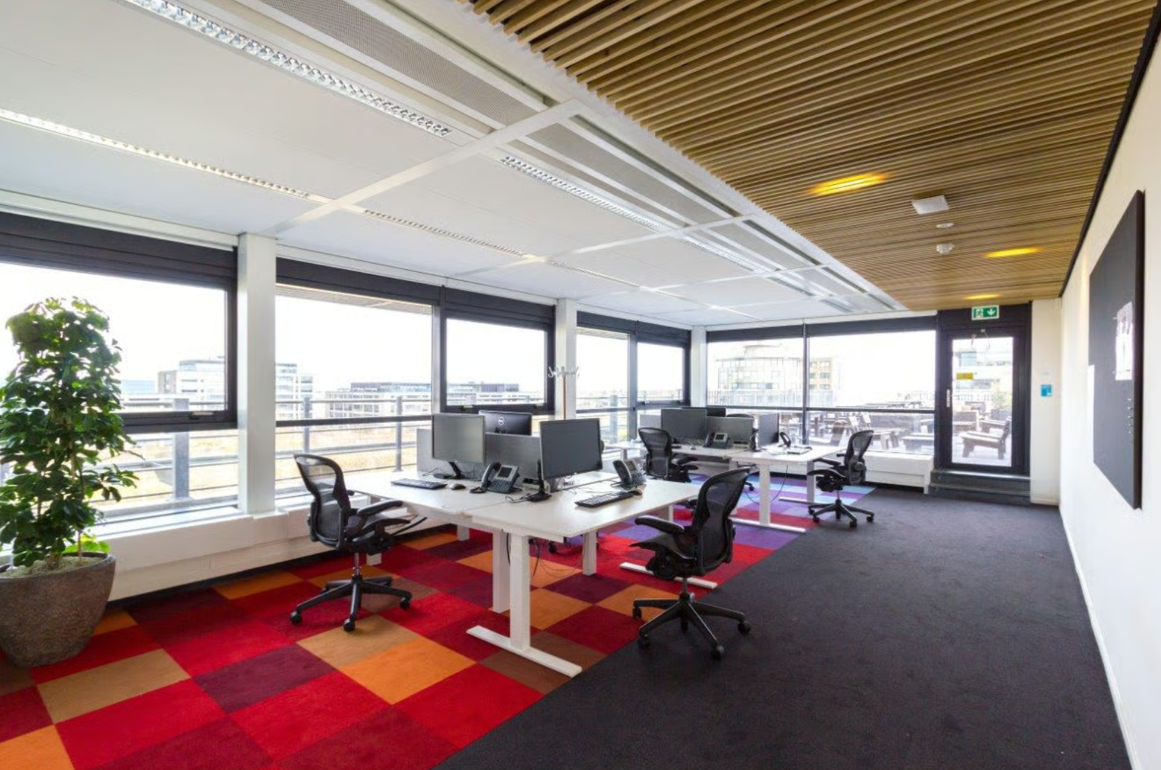 Modern open-plan office space on Boeing Avenue with multiple desks, computers, and large windows providing natural light.