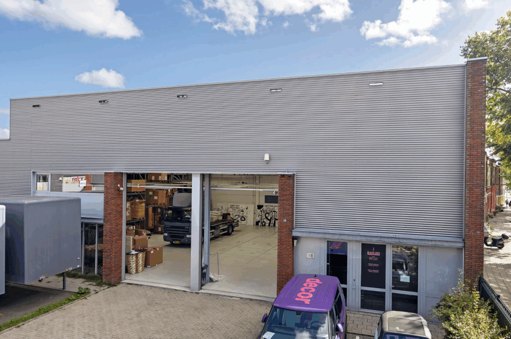 Exterior view of a commercial warehouse building on Schaafstraat with an open loading bay and parked vehicles.