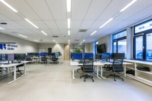 Modern en strak ingericht kantoor van Revenue Guru aan de Helicopterstraat met meerdere werkplekken en grote beeldschermen.