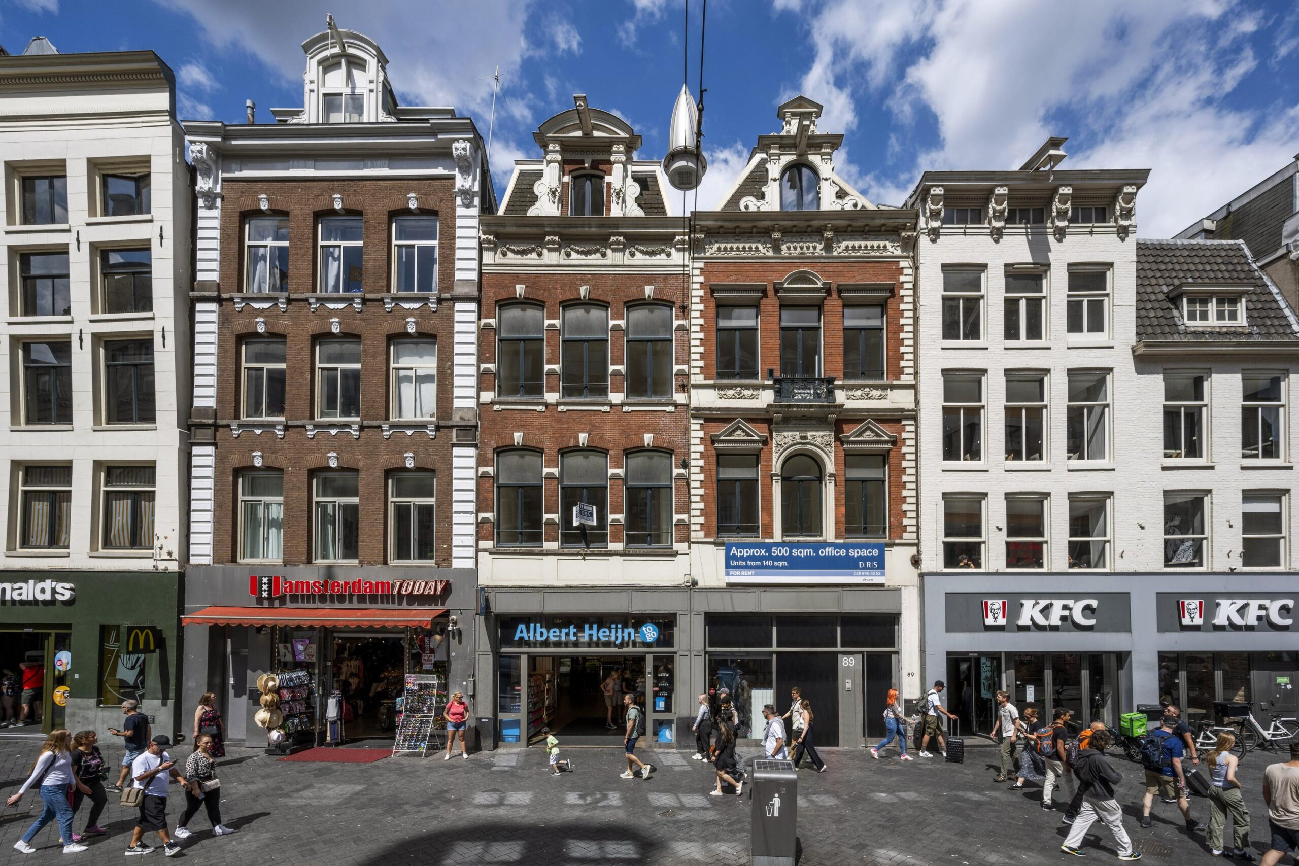 Winkelpanden aan het Damrak in Amsterdam met onder meer Amsterdam Today, Albert Heijn en KFC.