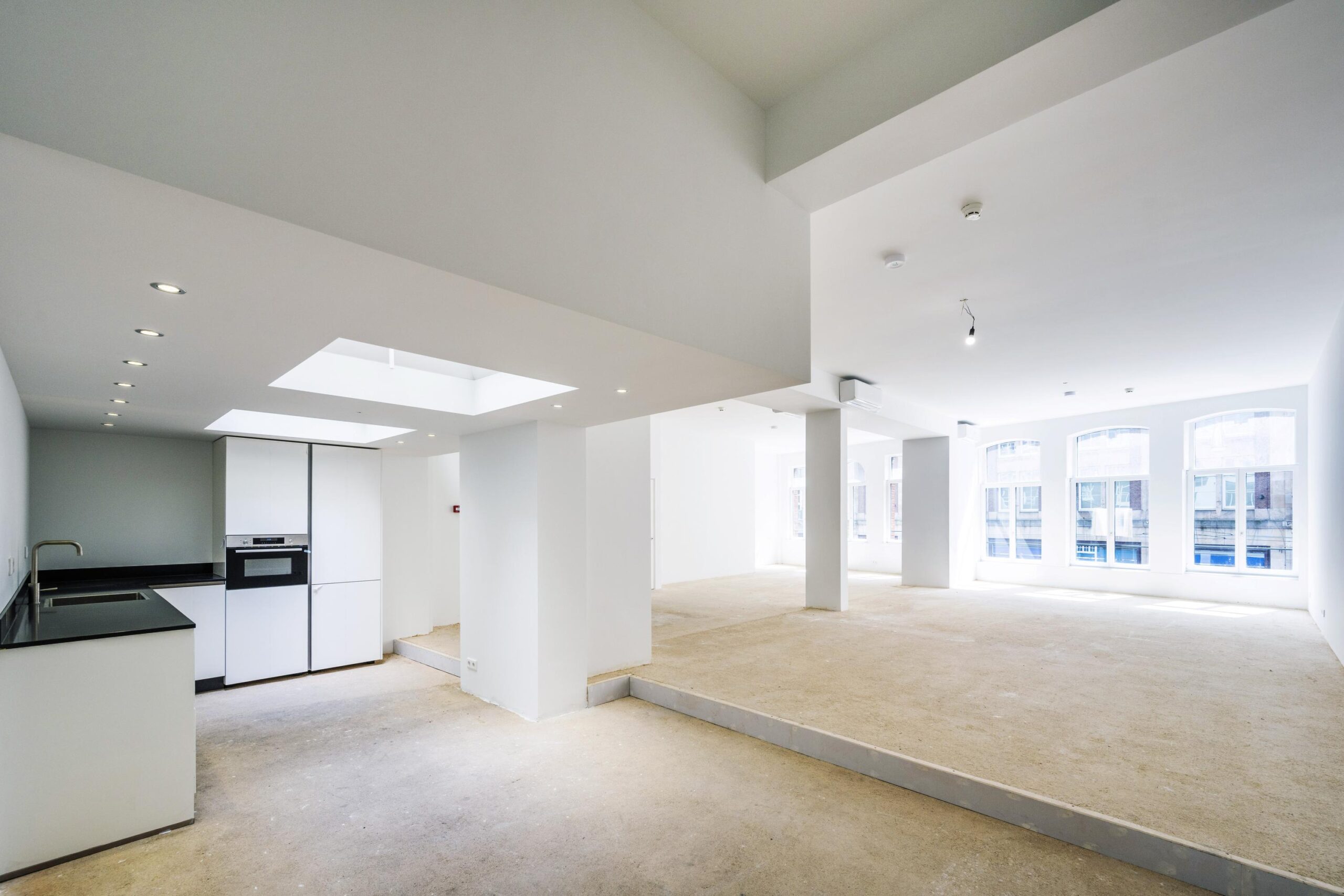 Licht en ruim casco-interieur met open keuken aan de Damrak in Amsterdam.