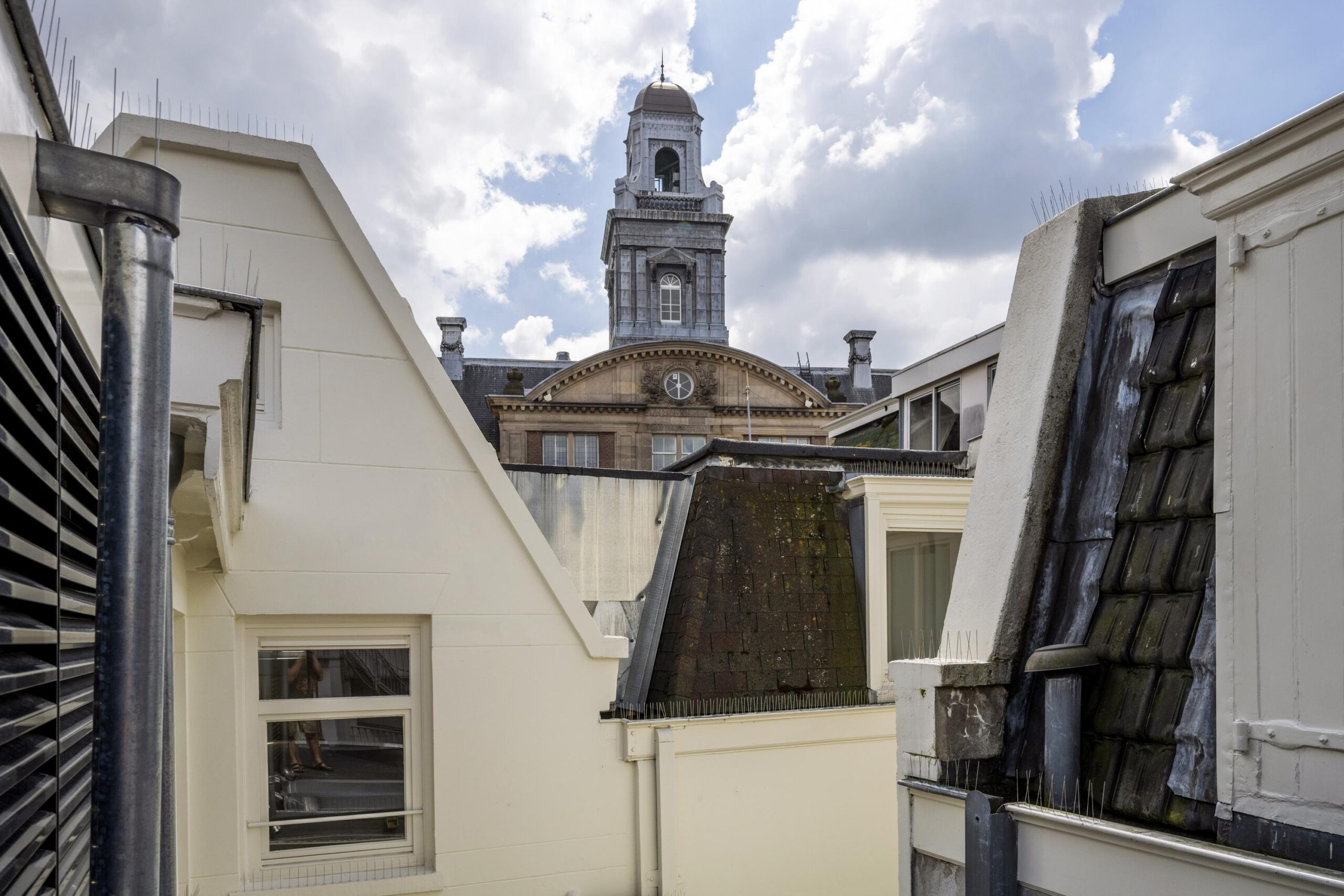 Uitzicht op de toren van het Beurs van Berlage-gebouw vanaf een binnenplaats aan het Damrak in Amsterdam.