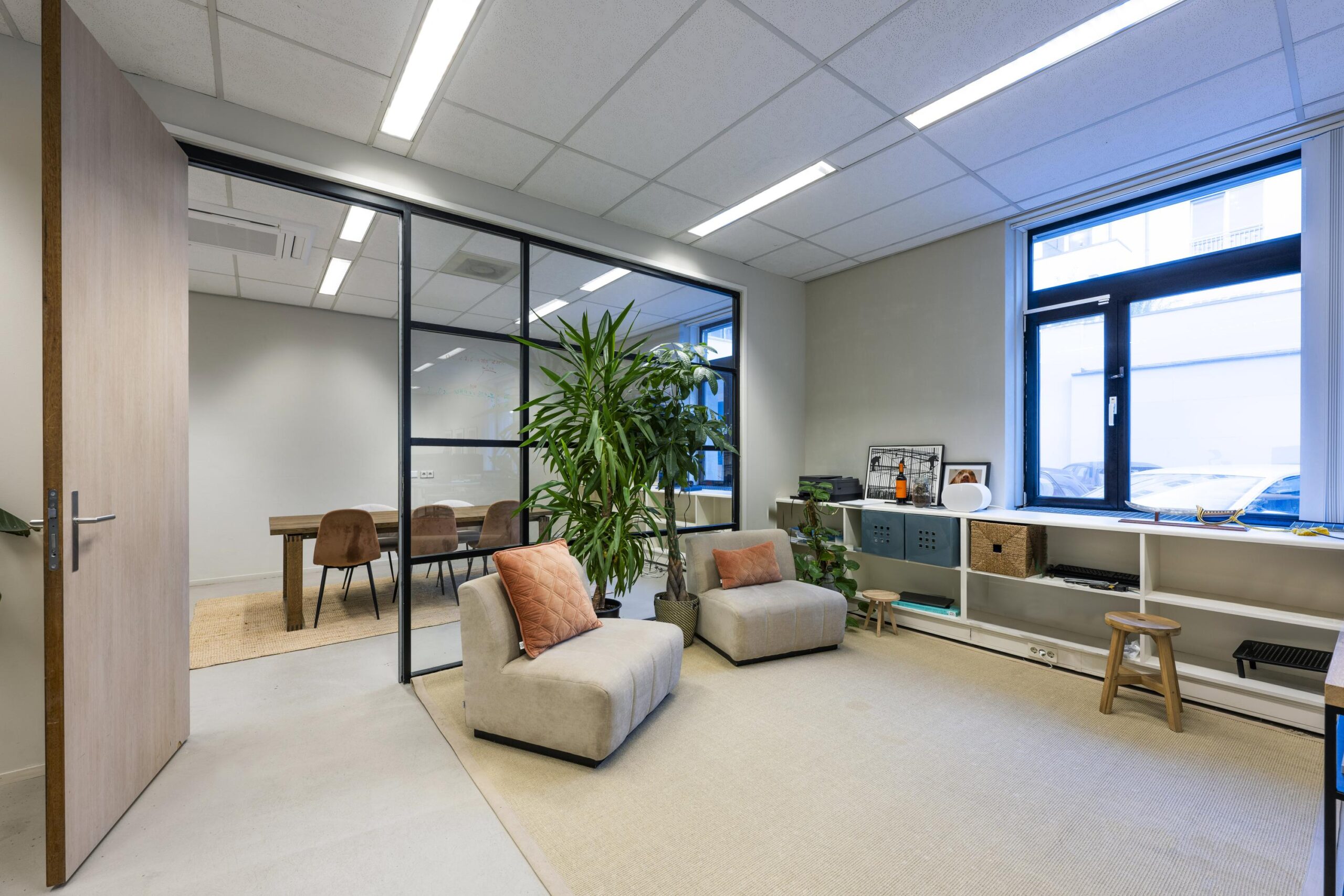 Moderne en lichte kantoorruimte aan de Helicopterstraat met zithoek, vergaderruimte en grote ramen.