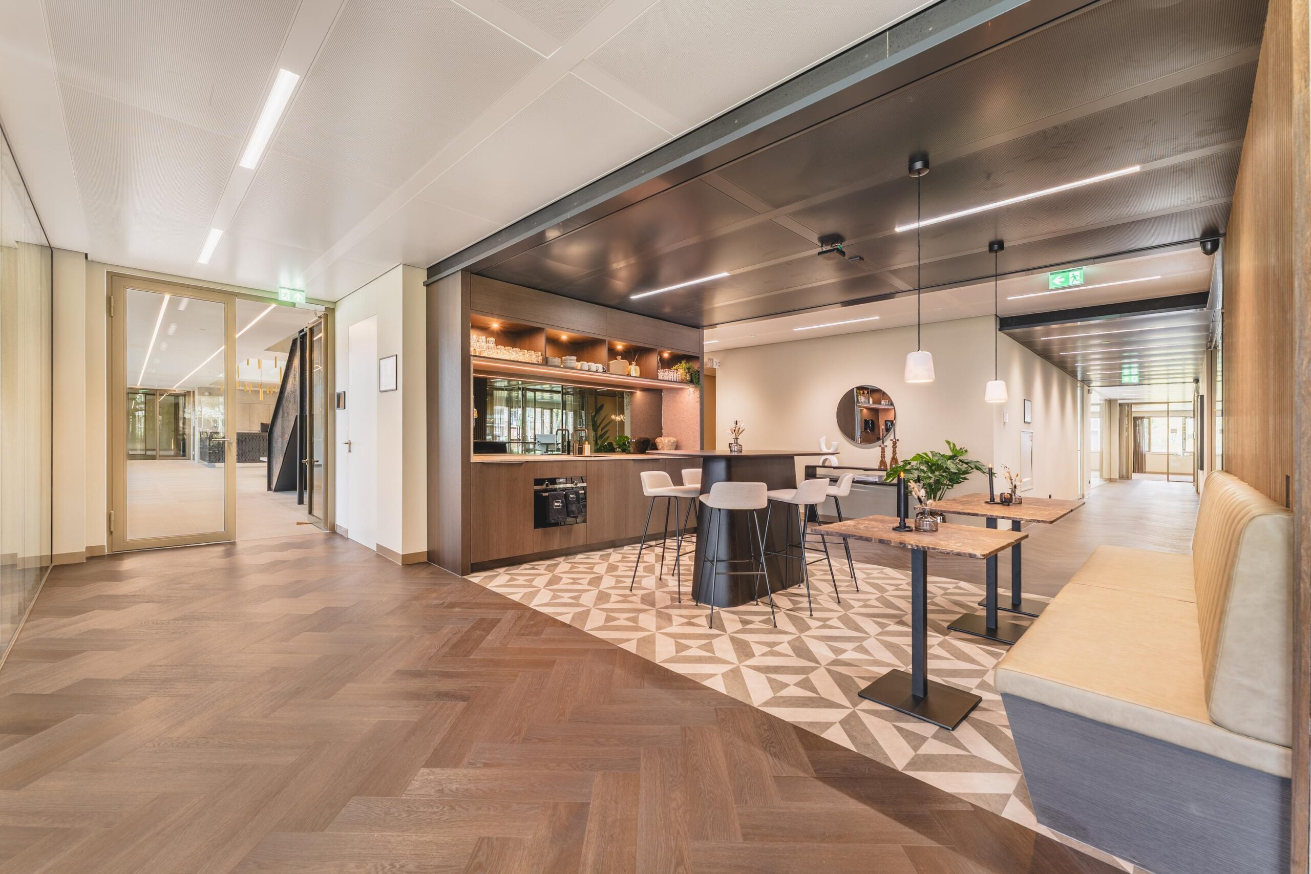 Modern office lounge area with a coffee bar, high tables, and cozy seating in the Walborg building.