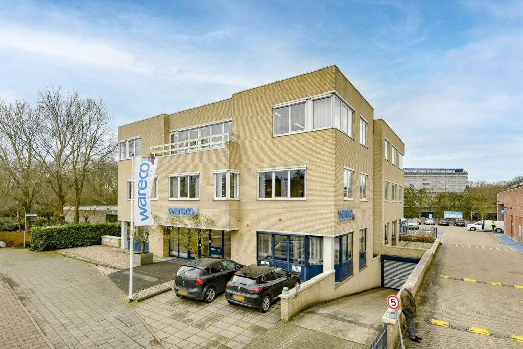Modern beige office building with "Wareco" branding, featuring large windows, parked cars, and a visible underground parking entrance.
