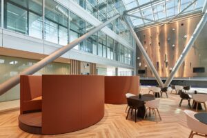 Moderne zithoek met tafels en stoelen in een open en licht atrium aan de Amstelveenseweg.