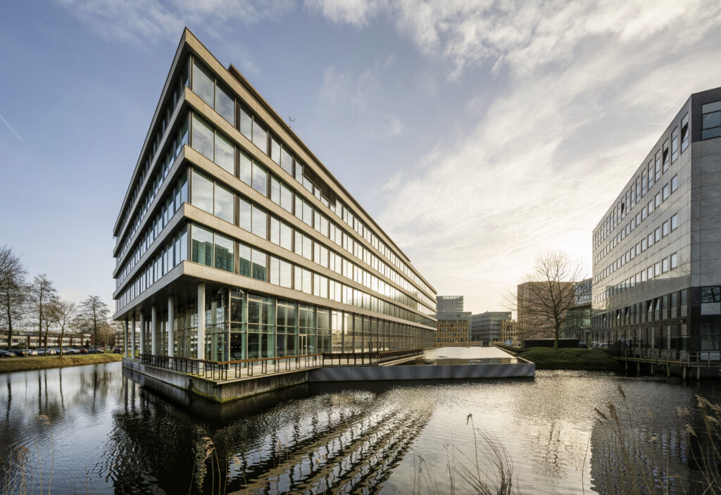 Modern kantoorgebouw Keynes 011 van architect Paul Starink met glazen gevels en waterpartij op de Zuidas in Amsterdam.