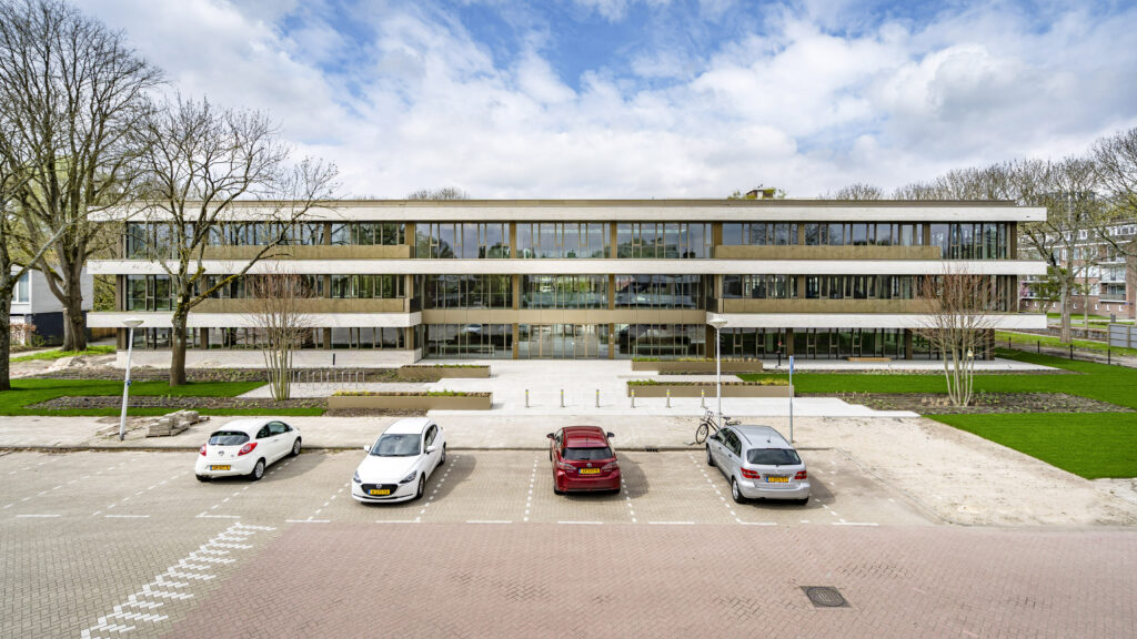 Vooraanzicht van het moderne kantoorpand Walborg Midden met parkeerplaatsen en groenvoorziening.